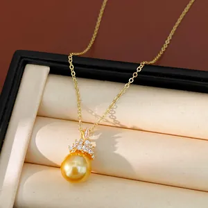 Détail d'un collier élégant plaqué or 18k avec une perle dorée et un pendentif couronne