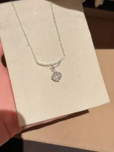 Close-up of sparkling zircon pendant necklace with star detail on beige display card