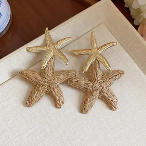 Detailed macro view of stylish gold and beige raffia woven starfish vacation stud earrings