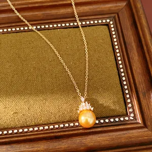 Gros plan d'un collier plaqué or 18 carats avec perle dorée et pendentif en zircon