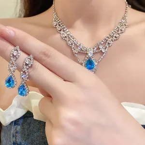 Gros plan d'une parure élégante collier et boucles d'oreilles en zircon bleu sur modèle