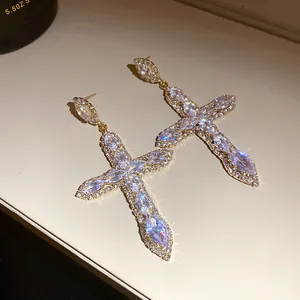 Close-up of luxury cross drop earrings encrusted with sparkling cubic zirconia stones
