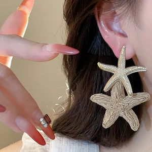 Detail showing the intricate textures of the raffia and gold-toned starfish elements.