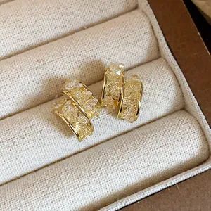 Macro detail of elegant 14k gold plated hoop earrings with sparkling crushed glass.