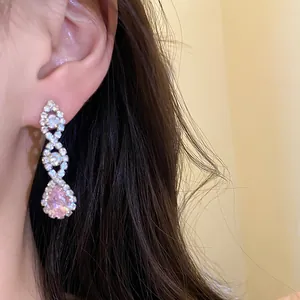 Gros plan de boucles d'oreilles pendantes élégantes en zircon rose sur un mannequin
