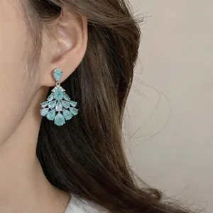 Detailed close-up of vintage luxury teardrop chandelier earrings with blue zircons
