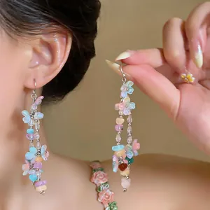Detailed view of colorful dopamine style resin flower and stone tassel earrings on ear