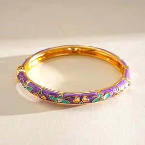 Detailansicht eines Vintage-Goldarmreifens mit lila Emaille und blaugrünen Blumenmustern