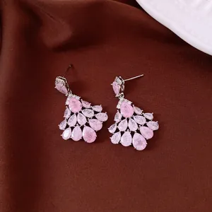 Close-up of luxury pink zircon teardrop cluster earrings with silver needles and gold plating