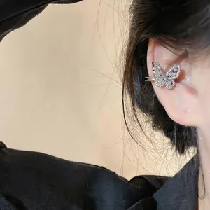 Primo piano di un ear cuff a farfalla con zirconi indossato sull'orecchio
