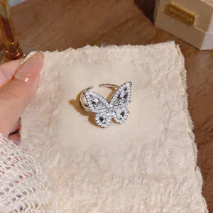 Elegante anello a farfalla in argento con zirconi su un cuscinetto beige testurizzato