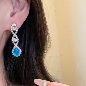 Gros plan de boucles d'oreilles pendantes argentées avec pierre bleue étincelante