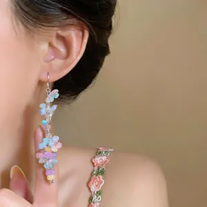 Detailed close-up of colorful resin flower and stone beaded tassel hook earrings