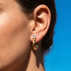 Macro view of elegant gold C-shaped titanium steel stud earring with pear zircon