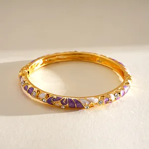 Detailansicht des goldenen Vintage-Armreifs mit lila Emaille-Blumen und Kristallen.