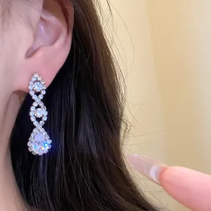Gros plan d'élégantes boucles d'oreilles pendantes en argent avec zircons brillants