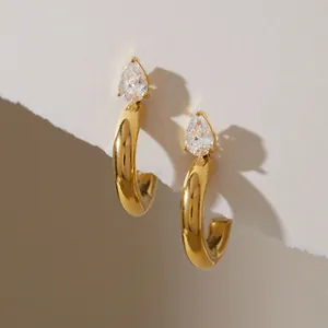 Detail of elegant gold C-shaped titanium steel hoop earrings with pear-cut zircon