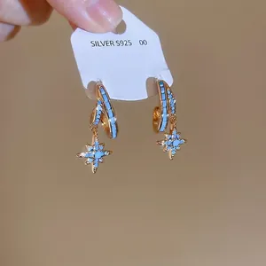 Elegant gold double-layer hoop earrings with blue star charms and sparkling zircon accents