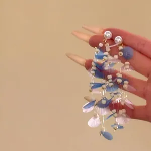 Elegant long tassel pearl earrings featuring blue shell petals for island resort style.