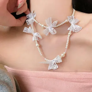 Detailed close-up showing an elegant pearl choker necklace with white lace bow accents