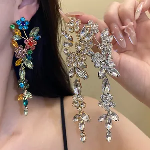 Close-up of sparkling flower tassel earrings with colorful and clear crystal drops.