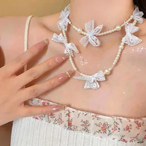 Detailed view of sweet French style lace bow and pearl necklace on a model's neck