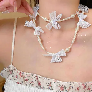 Detailed view of an elegant lace bow and beaded pearl choker in a sweet French style.