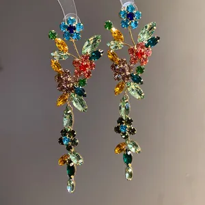 Detailed macro shot of vibrant multi-colored crystal flower tassel earrings with silver needles