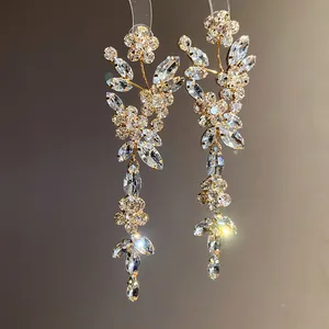 Close-up of silver needle floral tassel earrings with sparkling clear crystal stones