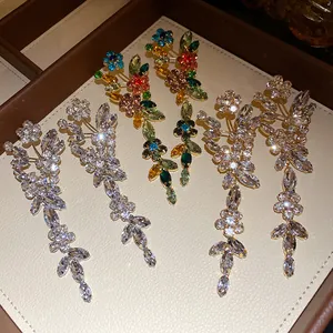 Detail of elegant silver needle earrings with sparkling crystal flower tassels on tray