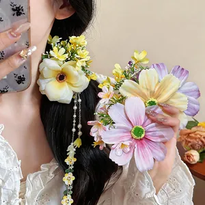 Gros plan d'une pince à cheveux fleur en tissu avec glands élégants et perles