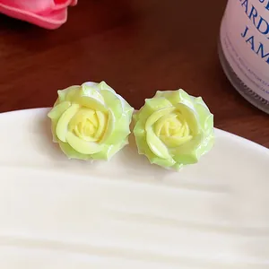 Detailed view of yellow resin rose stud earrings featuring delicate petal textures