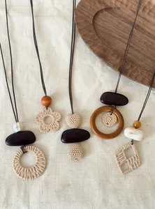 Detailed close-up of various Bohemian woven necklaces featuring wood and rattan elements.