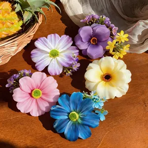 Gros plan de diverses pinces à cheveux fleurs en tissu sur une surface en bois.