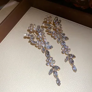 Detailed view of luxury silver needle flower tassel earrings with sparkling rhinestones