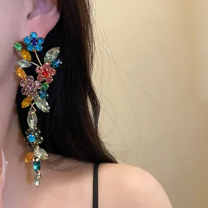 Detailed view of luxury colorful rhinestone floral tassel earrings on a model's ear