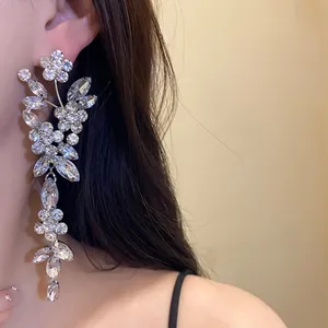Detailed view of elegant silver flower tassel earrings with sparkling rhinestones on model