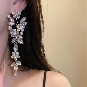 Detailed macro view of elegant silver rhinestone flower tassel earrings worn by a model