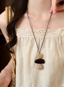Detail shot of a bohemian woven long necklace on a model for beach vacation style