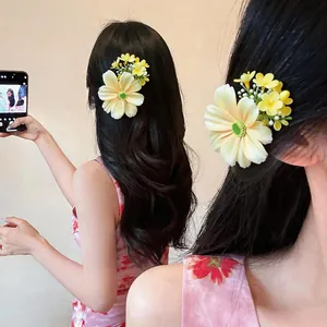 Vue détaillée de pinces à cheveux en tissu fleur de marguerite sur de longs cheveux