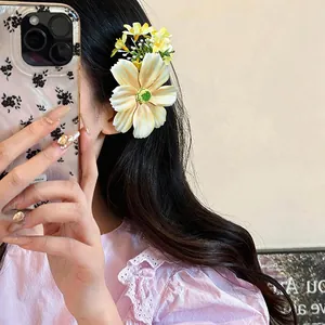 Gros plan d'une jolie pince à cheveux fleur en tissu sur cheveux noirs.