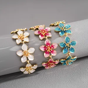 Detailed view of three colorful enameled flower bracelets in white, pink, and blue colors.