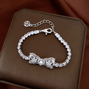 Detailed view of a silver bow bracelet featuring cubic zirconia and a central pearl
