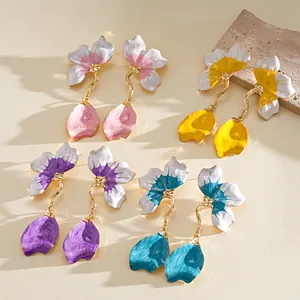 Detailed view of colorful enamel flower petal drop earrings in four vibrant shades