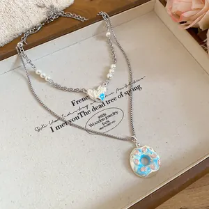 Gros plan sur un collier double rang avec pendentif donut bleu et cœur porte-bonheur