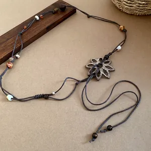 Handgefertigter brauner Webgürtel im Ethno-Stil mit Holzblumenschnalle und Perlen.