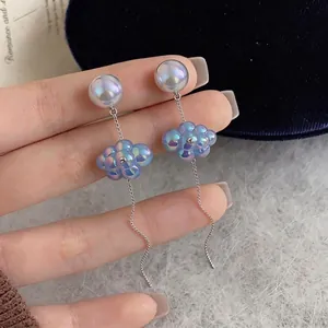 Eleganti orecchini a nuvola con perle e lunghe nappe argentate a onde.