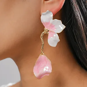 Close-up of elegant pink and white flower drip oil earrings on model showcasing intricate detail
