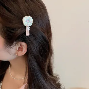 Détail en gros-plan d'une barrette donut avec pendentif cœur sur cheveux brun foncé