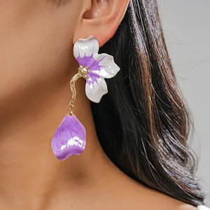 Exquisite close-up of a handmade purple and white enamel flower petal drop earring on model